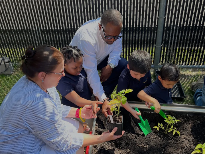 Commissioner Stanley J. Neron helping students prepare their garden and add new plants