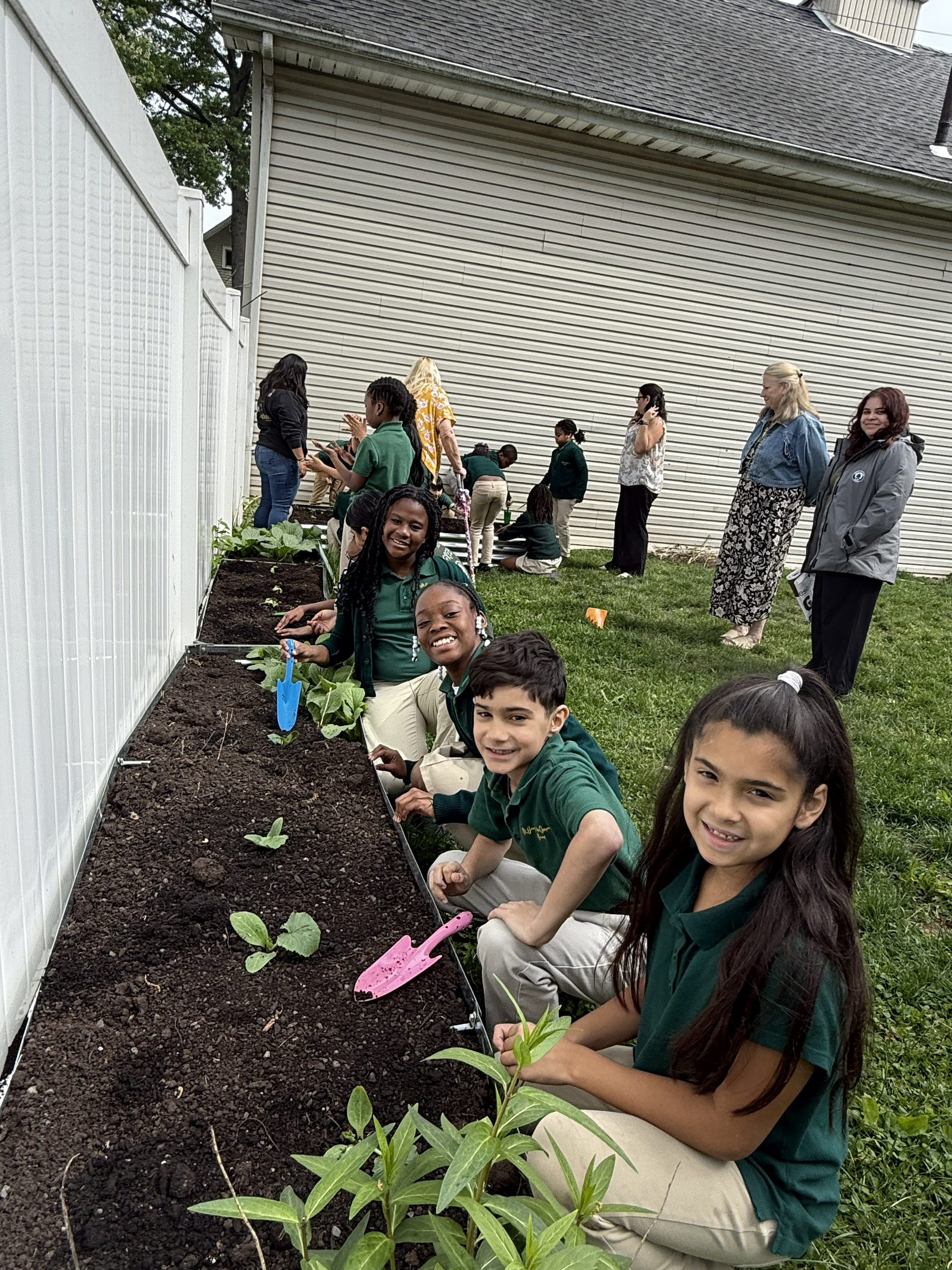 St. Joseph students taking a break from working on their garden to smile for the camera