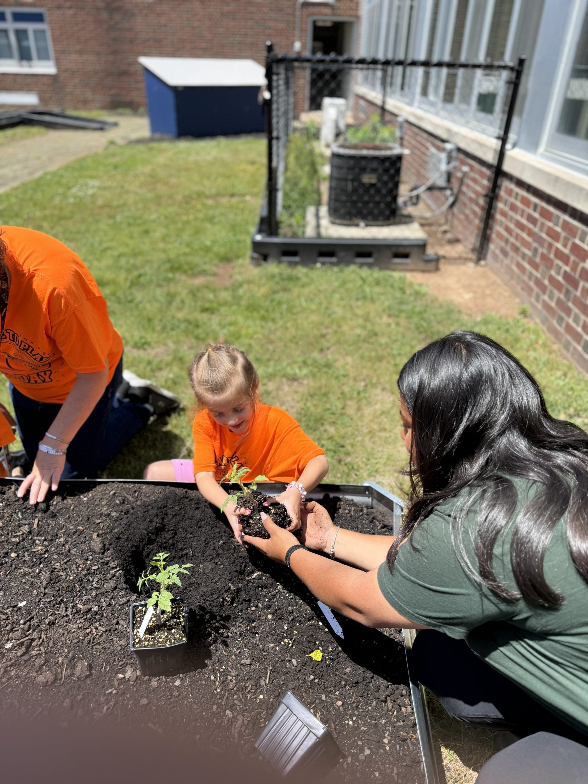 image of Clark Pre-K students planting in their raised garden bed