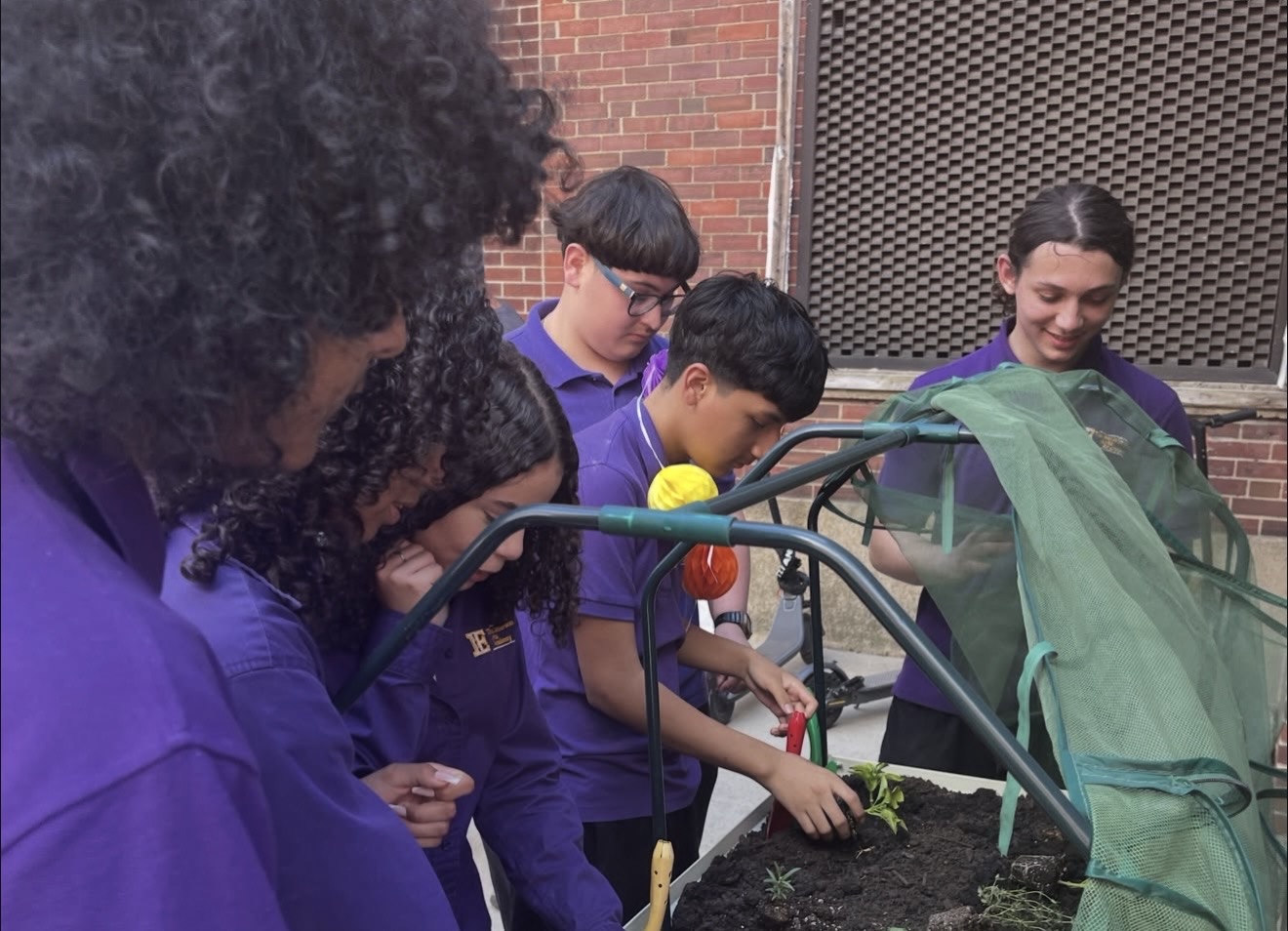 TJAA students planting in their ADA compliant raised garden bed 