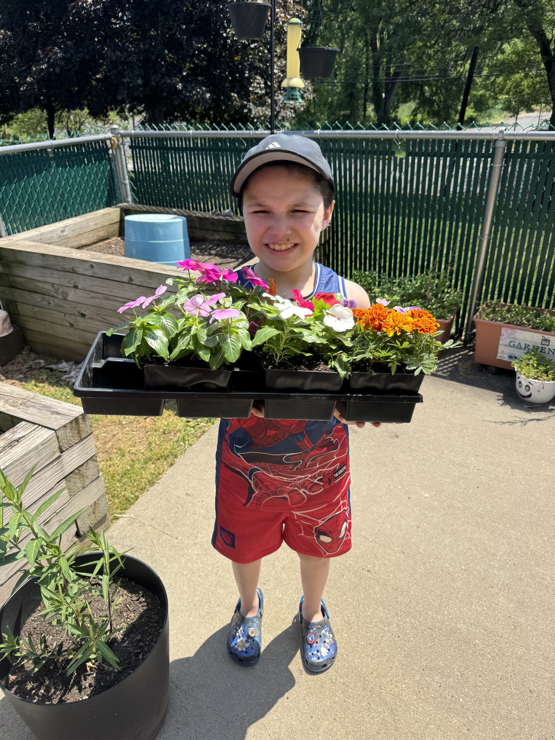 student holding several flower plant starters, reading to be planted. 