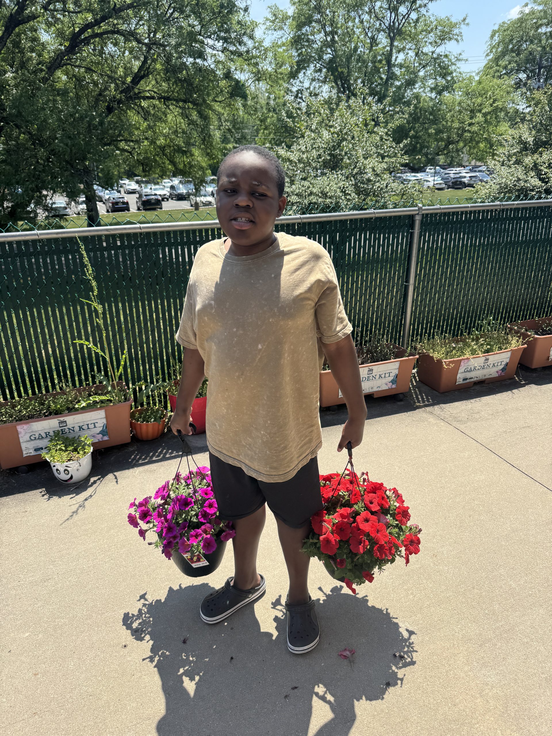 image of student holding two hanging flower pots