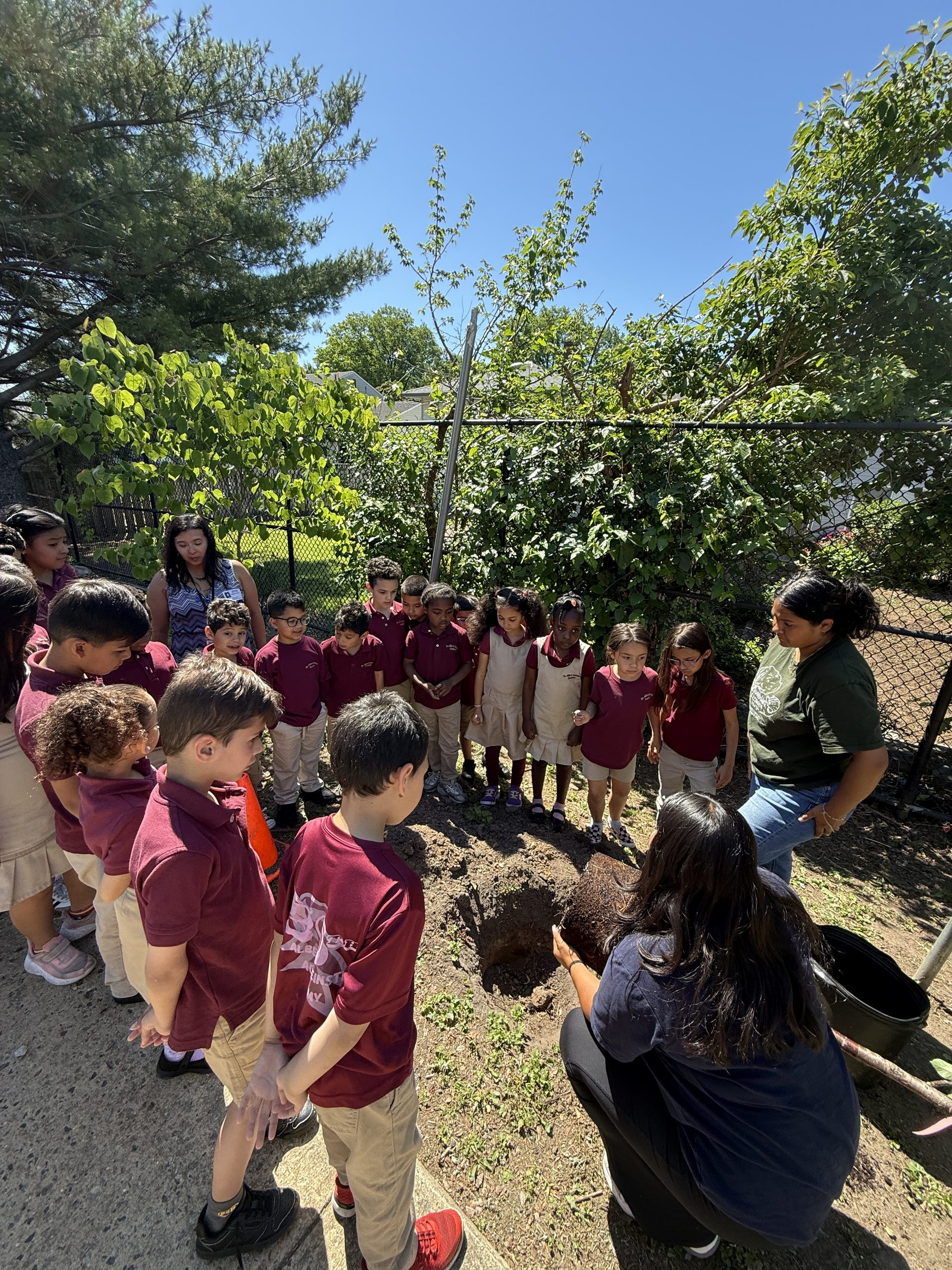 Dr. Albert Einstein Academy students listening to a Groundworks Elizabeth representative as she is holding their new cherry tree
