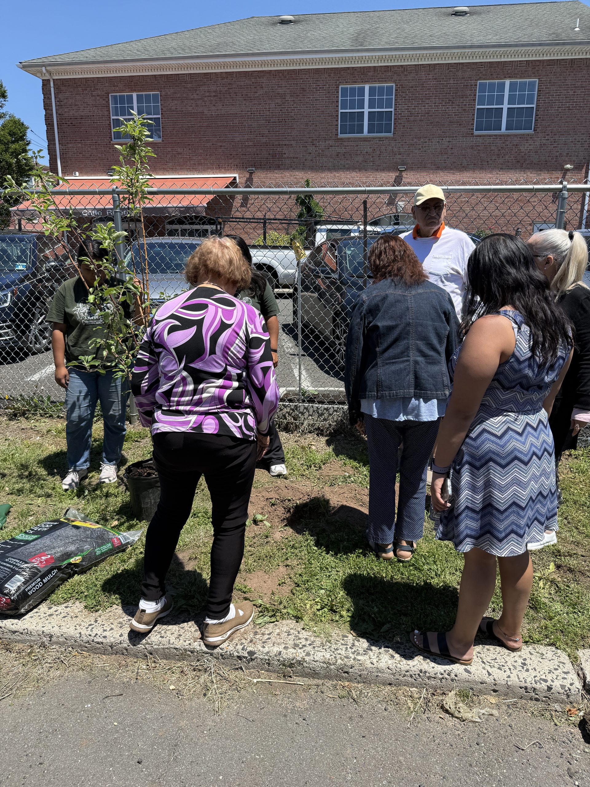 Groundworks Elizabeth staff giving brief presentation to Peterstown Community Center members before planting apple tree