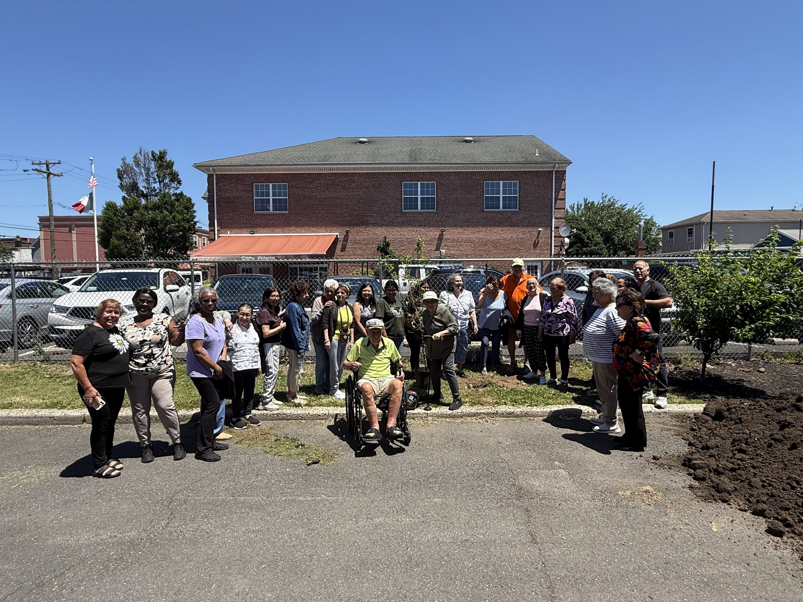 Peterstown Community Center, Groundworks Elizabeth staff and Union County representatives smile and pose for the camera with their new apple tree