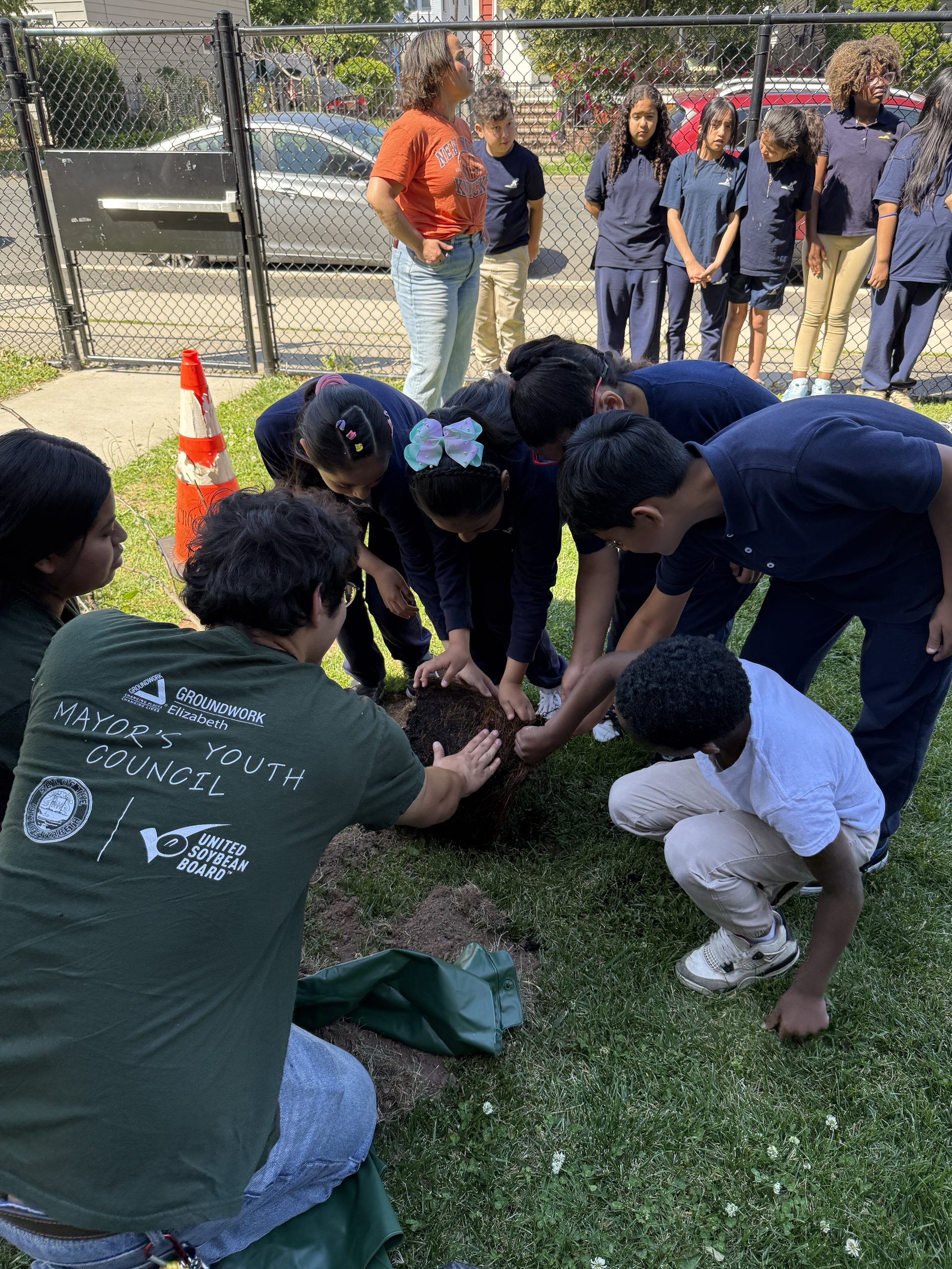 John Marshall School No. 20 students and Groundworks Elizabeth staff planting the apple tree