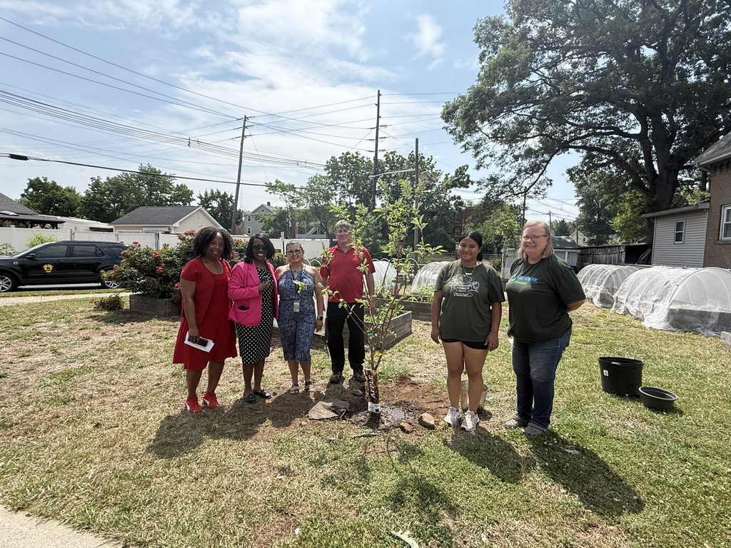 Community members gathered around an apple tree.