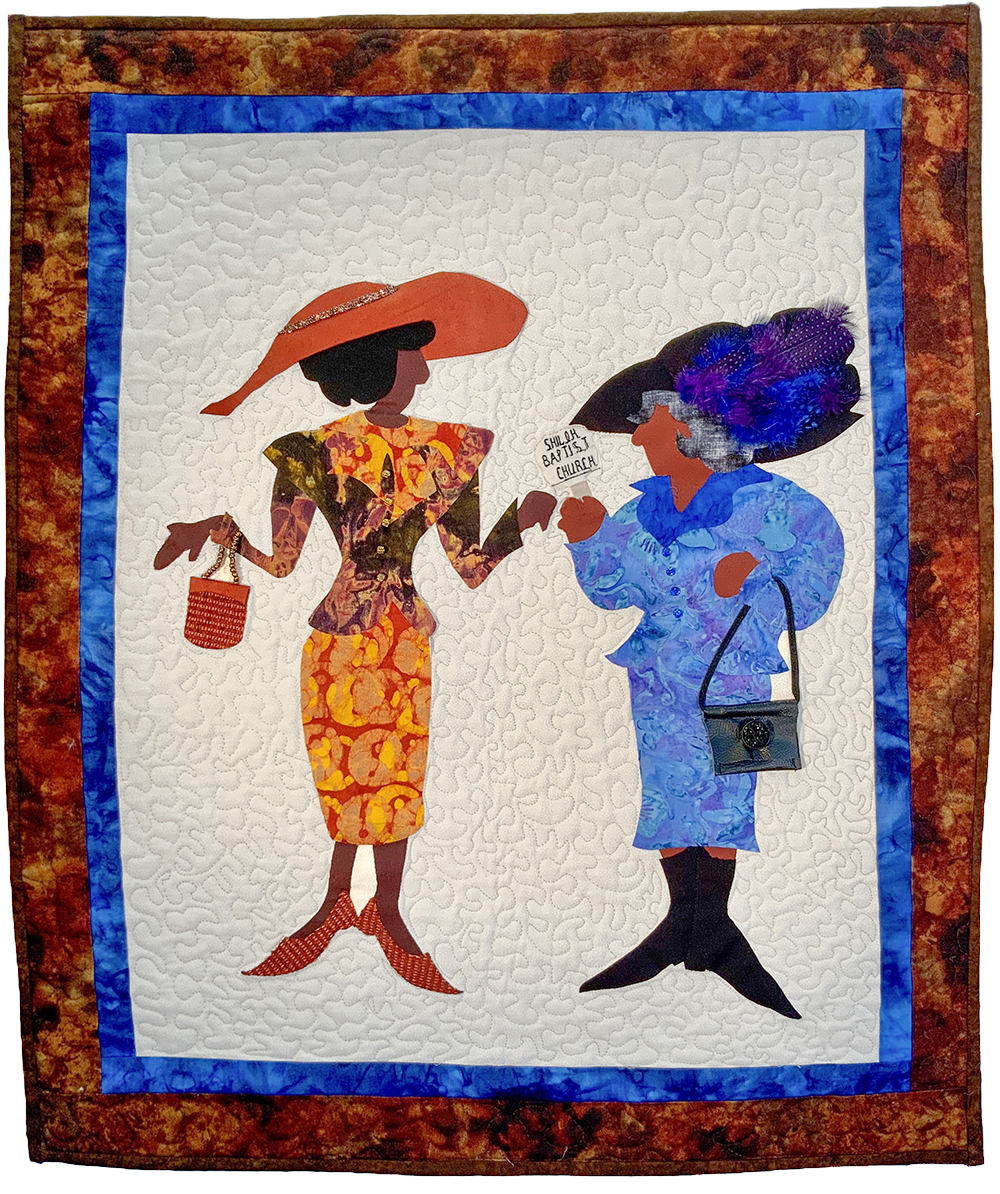 Lynda DuBois-Jackson was awarded First Place for Craft by a Professional artist for this quilt, titled “Church Ladies.” Her quilt has a thick outer border of brown-patterned fabric, and a thinner inner border of contrasting blue-patterned fabric. In the center, the striking figures of two women appear on bone-colored background fabric. They are women of color, dressed for church in bright-colored outfits and heels. The artist crafted the figures using a variety of fabrics. Real buttons are sewn onto their outfits. The woman on the left side wears a skirt and jacket of golden hues, and a wide-brimmed hat. She holds a purse – its handle made of real beads. The woman on the right wears a skirt and jacket of blue-purple printed fabric. Her hat is adorned with real feathers, bright blue and purple. At the center of the quilt, she holds a church bulletin that reads “Shiloh Baptist Church.”