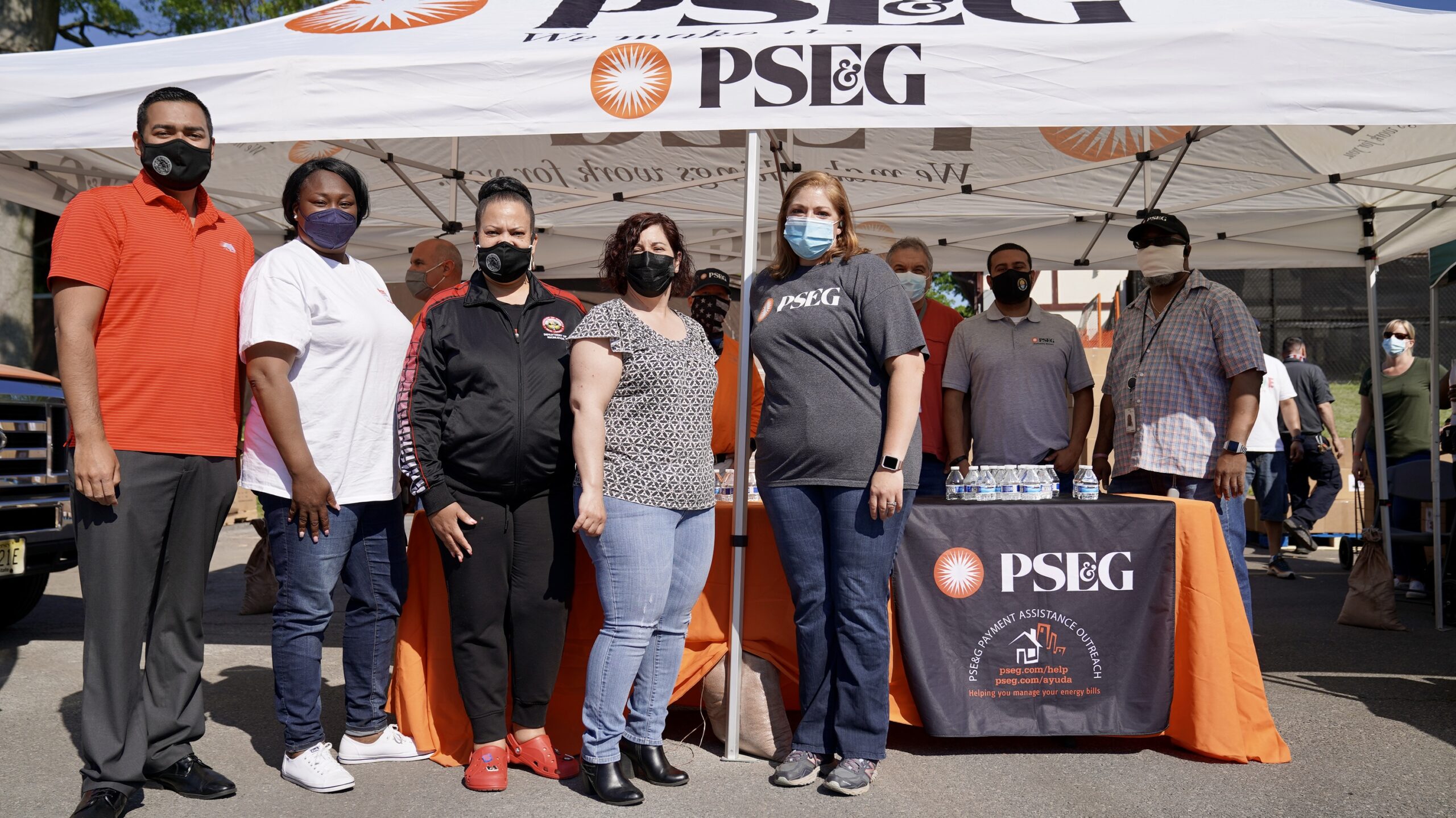 people standing in front of pse&g pop up tent and table for a photo