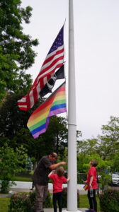 american and pride flag flying on a flagpole
