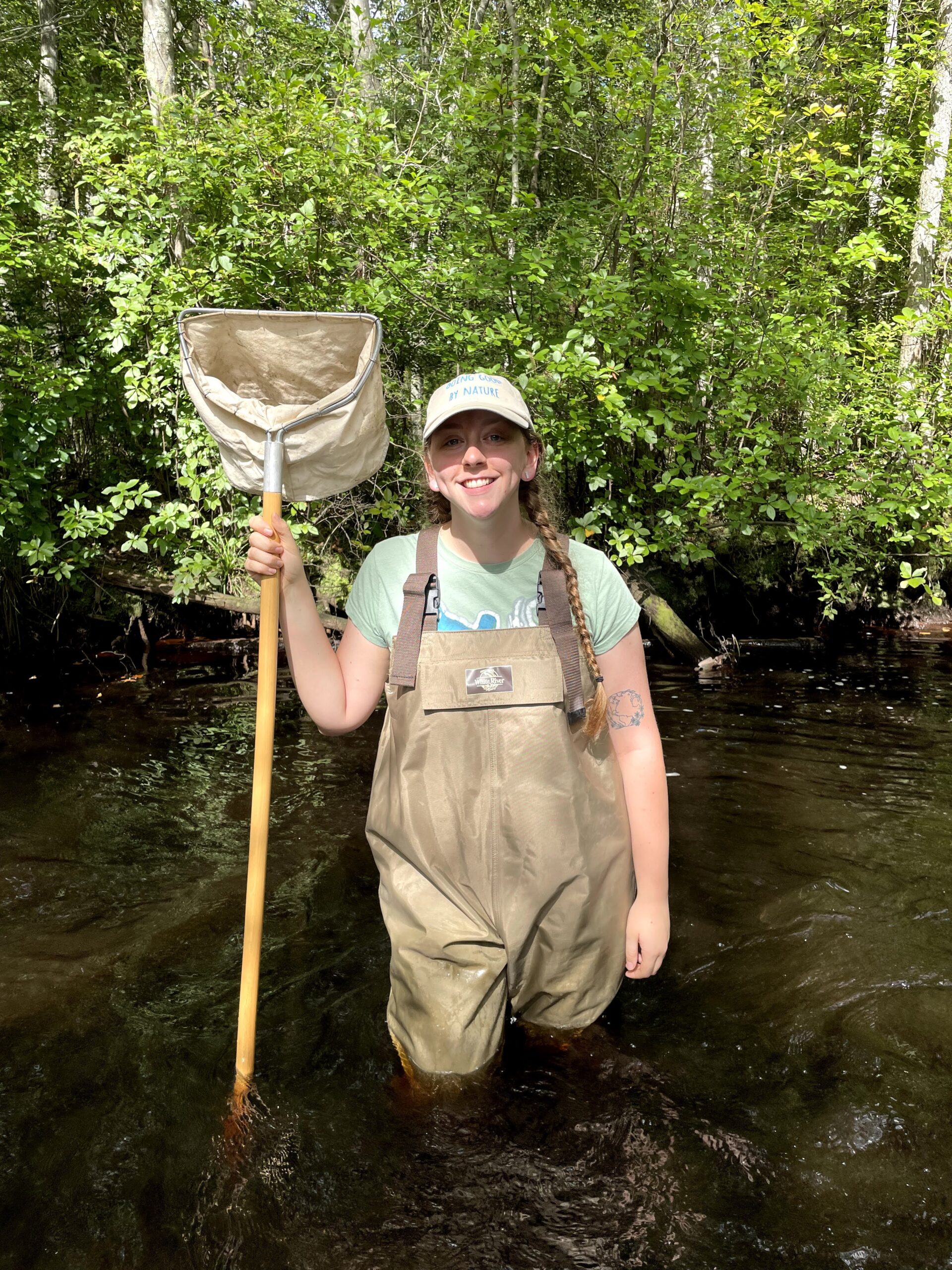 AmeriCorps Watershed Ambassador, Cassidy Attanasio in knee high water with a poled net