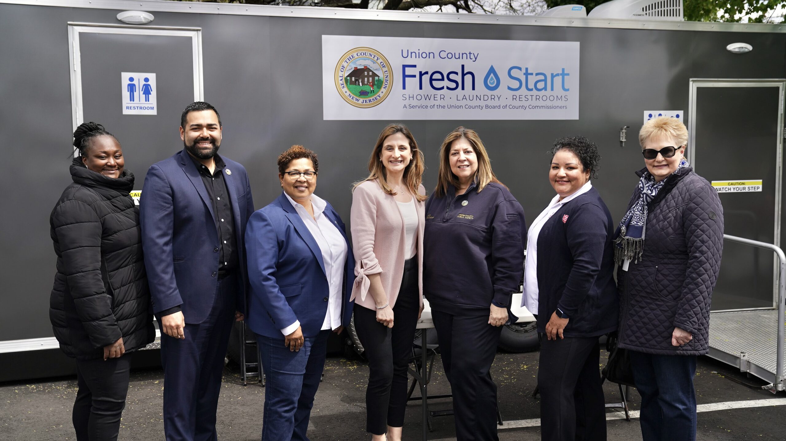 commissioners standing in front fresh start trailer